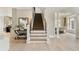 Bright foyer featuring hardwood floors, staircase, and access to multiple rooms at 9035 Brixham Ct, Suwanee, GA 30024
