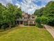 Charming two-story brick home with beautiful front yard, landscaping, and mature trees at 9035 Brixham Ct, Suwanee, GA 30024