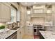 The gourmet kitchen features custom cabinets, granite counters, stainless steel appliances and a decorative backsplash at 9035 Brixham Ct, Suwanee, GA 30024