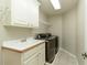 A practical laundry room equipped with a sink, cabinets, and modern washer and dryer at 9035 Brixham Ct, Suwanee, GA 30024