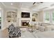 Living room featuring a stone fireplace, built-in shelving, and a comfortable seating area at 9035 Brixham Ct, Suwanee, GA 30024