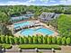 A luxurious community pool with multiple lounge chairs, tables and a clubhouse in the background at 9035 Brixham Ct, Suwanee, GA 30024