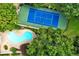 Stunning aerial view showcases a blue tennis court and sparkling pool surrounded by lush green trees at 13 Ivy Ne Sq, Atlanta, GA 30342