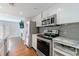 Modern kitchen featuring stainless steel appliances, granite countertops, gray backsplash, and white cabinets at 13 Ivy Ne Sq, Atlanta, GA 30342