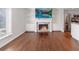 Living room view with a fireplace, built-in shelves, wood floors, and access to the kitchen at 13 Ivy Ne Sq, Atlanta, GA 30342