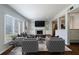 Sunlit living room featuring stylish seating, fireplace, and an open layout to the kitchen at 13 Ivy Ne Sq, Atlanta, GA 30342