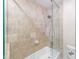 Glass-enclosed shower and tub with neutral tile and modern fixtures at 13 Ivy Ne Sq, Atlanta, GA 30342