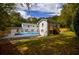 Spacious backyard featuring a pool, patio, and lush greenery surrounding the painted brick house at 4395 Woodland Brook Se Dr, Atlanta, GA 30339