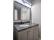 Modern bathroom featuring a gray vanity with sleek black fixtures and a framed mirror at 4395 Woodland Brook Se Dr, Atlanta, GA 30339