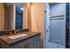 Modern bathroom featuring a gray vanity with gold fixtures and a glass enclosed shower at 4395 Woodland Brook Se Dr, Atlanta, GA 30339