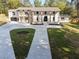 Front exterior showcasing a home with classic columns, fresh sod and a curved driveway at 4395 Woodland Brook Se Dr, Atlanta, GA 30339