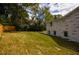 Large grassy backyard featuring a painted brick house and wood fence at 4395 Woodland Brook Se Dr, Atlanta, GA 30339