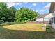 The spacious backyard features mature trees, a lawn, a wood fence, and a covered patio at 510 Winder Trl, Canton, GA 30114