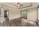This main bedroom has a tray ceiling, ceiling fan, and hardwood floors at 510 Winder Trl, Canton, GA 30114