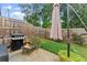 Cozy backyard featuring a grill, fire pit, and well-maintained lawn, perfect for outdoor entertaining at 61 N Auburn Landing Pl, Auburn, GA 30011