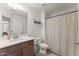 Bathroom with a single sink with shaker cabinets, quartz counters, and tub with shower curtain at 61 N Auburn Landing Pl, Auburn, GA 30011