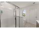 Bright bathroom featuring a walk-in shower with glass door and soaking tub beside a window at 61 N Auburn Landing Pl, Auburn, GA 30011