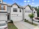Beautiful townhome exteriors featuring white paint, black trim, and attached garages at 61 N Auburn Landing Pl, Auburn, GA 30011