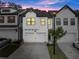 Beautiful townhome exterior at dusk, featuring a well-lit facade and inviting ambiance at 61 N Auburn Landing Pl, Auburn, GA 30011