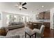 Open-concept living room featuring a ceiling fan, sofa, and adjacent kitchen at 61 N Auburn Landing Pl, Auburn, GA 30011