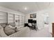 Bright living room with a built-in bookshelf, workstation, and comfortable seating area at 61 N Auburn Landing Pl, Auburn, GA 30011
