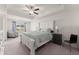 Tranquil main bedroom with a tray ceiling, fan, and a sitting area by the window at 61 N Auburn Landing Pl, Auburn, GA 30011