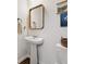 Traditional powder room featuring a pedestal sink, framed mirror, and modern fixtures at 701 Woodward Ct, Canton, GA 30114