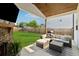 Inviting covered patio with a fireplace, lounge seating, and view of the backyard at 701 Woodward Ct, Canton, GA 30114