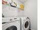Bright laundry room with modern washer and dryer set and wire storage shelf at 701 Woodward Ct, Canton, GA 30114