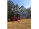 Exterior view of the home with a large back deck surrounded by mature trees at 102 Neal Ave, Stockbridge, GA 30281