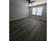 Bedroom with wood-look flooring, neutral walls, white trim, a ceiling fan and natural light at 102 Neal Ave, Stockbridge, GA 30281