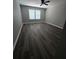 Bedroom with wood-look flooring, neutral walls, white trim, a ceiling fan and natural light at 102 Neal Ave, Stockbridge, GA 30281