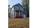 Two-story home with navy siding, white trim, a red porch, an attached two car garage and nice landscaping at 102 Neal Ave, Stockbridge, GA 30281