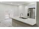 Kitchen island features a granite countertop, stainless steel sink, and modern fixtures at 102 Neal Ave, Stockbridge, GA 30281