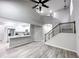 Open-concept living area features high ceilings, stairs, and a modern kitchen with stainless steel appliances at 102 Neal Ave, Stockbridge, GA 30281