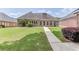 Brick home featuring a lush green lawn, manicured landscaping, and a concrete walkway at 1125 Lewis Ridge Cir, Lawrenceville, GA 30045