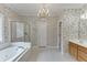Elegant bathroom features a floral wall paper, chandelier and a soaking tub with shower at 1125 Lewis Ridge Cir, Lawrenceville, GA 30045