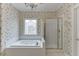 Bright bathroom features a soaking tub, decorative window, and glass shower at 1125 Lewis Ridge Cir, Lawrenceville, GA 30045