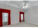 Spacious bedroom with soft neutral carpet, ceiling fan, and bright red curtains at 1125 Lewis Ridge Cir, Lawrenceville, GA 30045