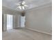 Open bedroom featuring soft neutral carpet, ceiling fan, and access to the Primary bathroom at 1125 Lewis Ridge Cir, Lawrenceville, GA 30045
