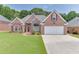 Charming brick home featuring a manicured lawn, two-car garage, and tasteful landscaping at 1125 Lewis Ridge Cir, Lawrenceville, GA 30045