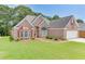 Beautiful brick home boasts a lush front lawn and a two-car garage, enhancing its curb appeal at 1125 Lewis Ridge Cir, Lawrenceville, GA 30045
