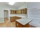 Bright kitchen with white countertops, wooden cabinets, and wood flooring at 1125 Lewis Ridge Cir, Lawrenceville, GA 30045