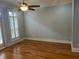 Neutral-toned bedroom featuring hardwood floors, plantation shutters, a lighted ceiling fan, and simple trim at 2380 Crescent Park Ct # 4, Atlanta, GA 30339