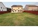 Spacious backyard featuring a lawn, wooden fence, and a covered patio area at 442 Snow Owl Way, Lawrenceville, GA 30044