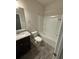 Bathroom featuring a tub and shower combination, a vanity with a granite countertop, and gray tile floors at 442 Snow Owl Way, Lawrenceville, GA 30044