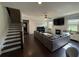Open concept living room with dark hardwood floors, a fireplace, and a gray sectional sofa at 442 Snow Owl Way, Lawrenceville, GA 30044