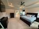 Large main bedroom featuring tray ceilings, neutral carpet, and a doorway leading to the bathroom at 442 Snow Owl Way, Lawrenceville, GA 30044
