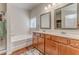 Bathroom featuring a vanity with dual mirrors, shower-tub combo, and wood-style flooring at 105 Silver Trce, Dallas, GA 30157