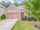 Charming home featuring a stone facade, two-car garage, manicured lawn, and meticulously maintained landscaping at 105 Silver Trce, Dallas, GA 30157